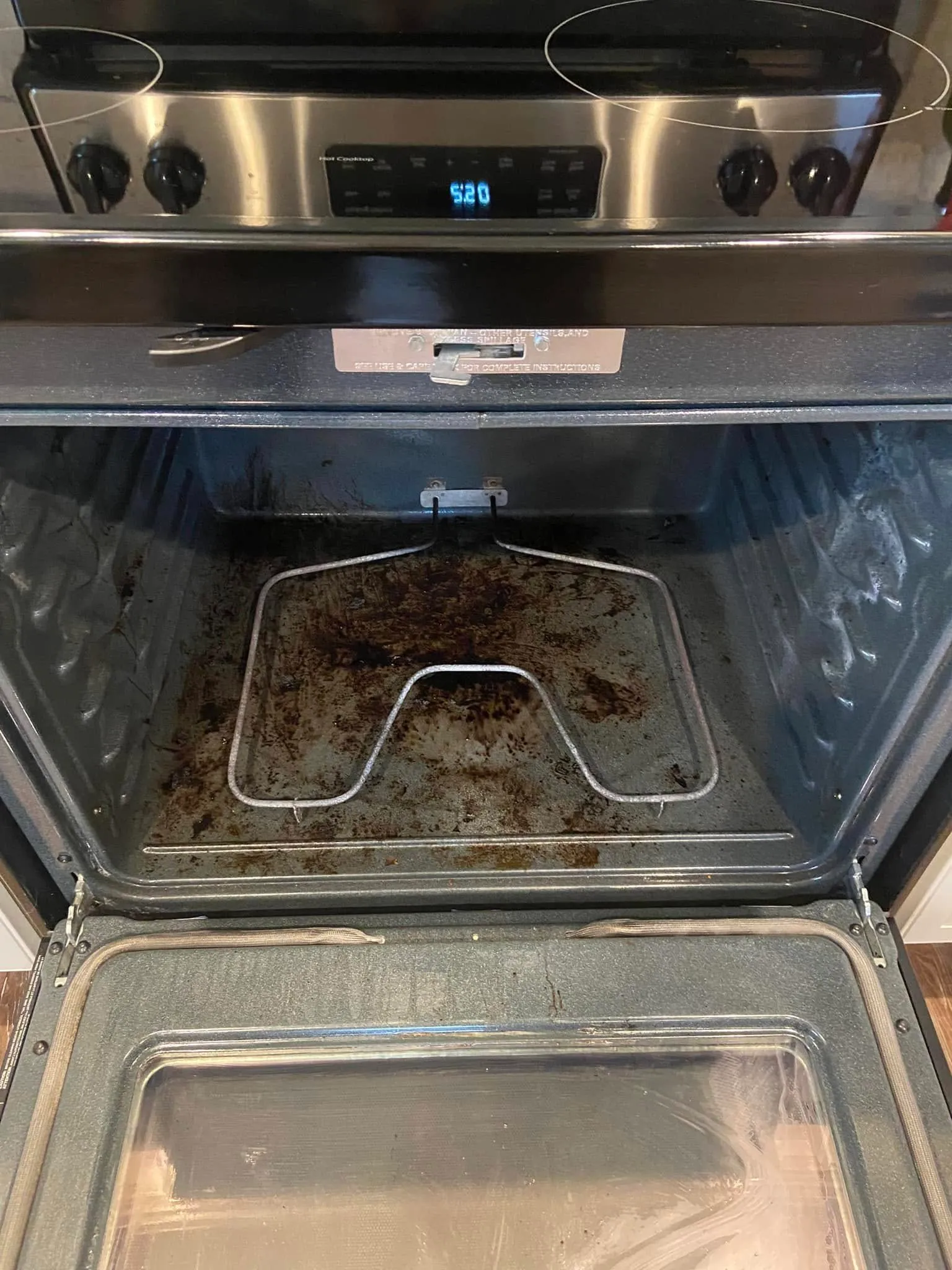 Before cleaning: baked-on residue inside an oven and on its glass door
