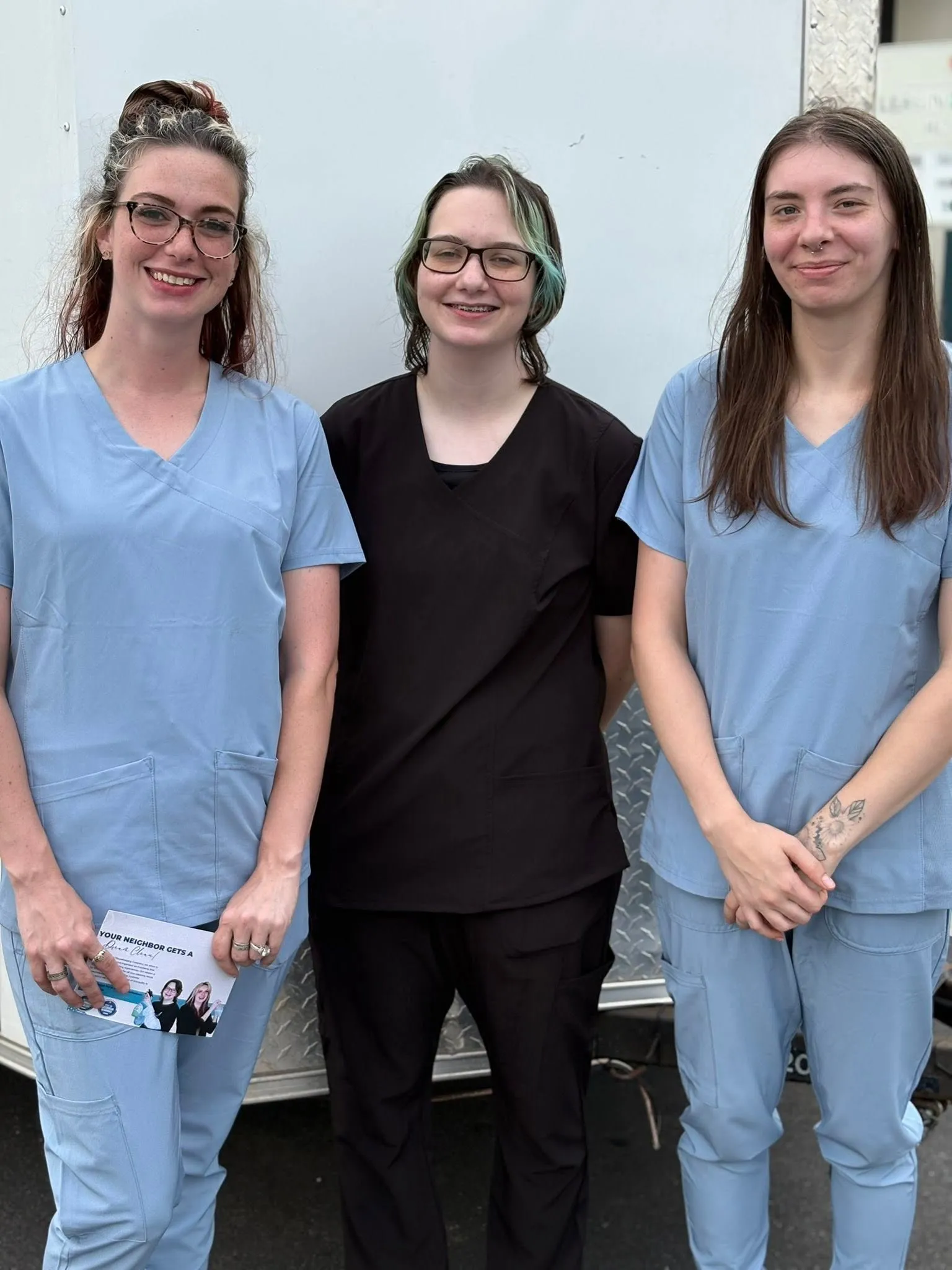 Three members of the Dream Clean team standing together in blue and black uniforms